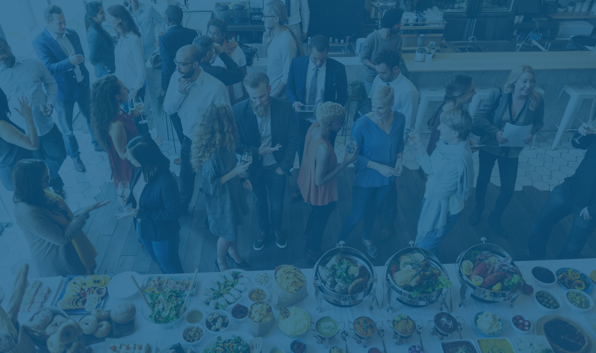 A group of friends gathered around a table filled with delicious food, enjoying each other's company.